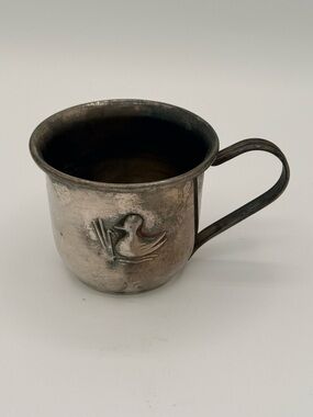 Vintage silver-plated child's cup with embossed duckling motif.